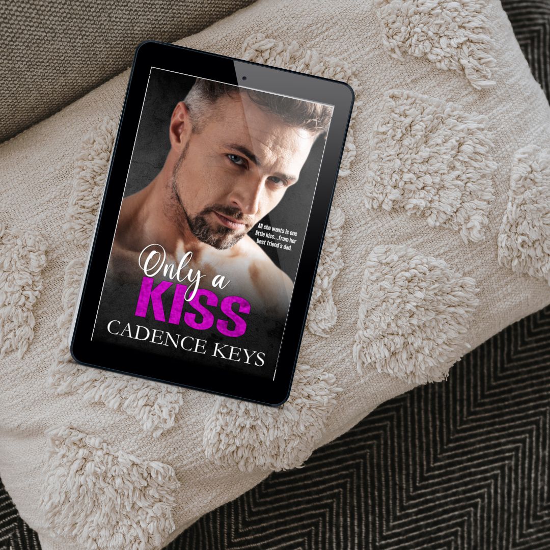 tablet with ebook cover of only a kiss by cadence keys on a beige pillow